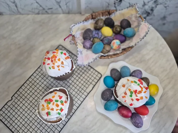 Пасхальные куличи с крашенными яйцами на тарелке.